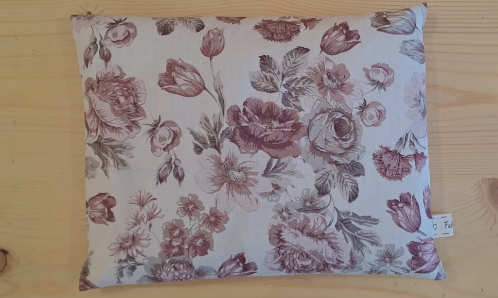 Cuscino rettangolare con noccioli di ciliegia, federa esterna con disegni di rose nelle tonalità del rosa antico