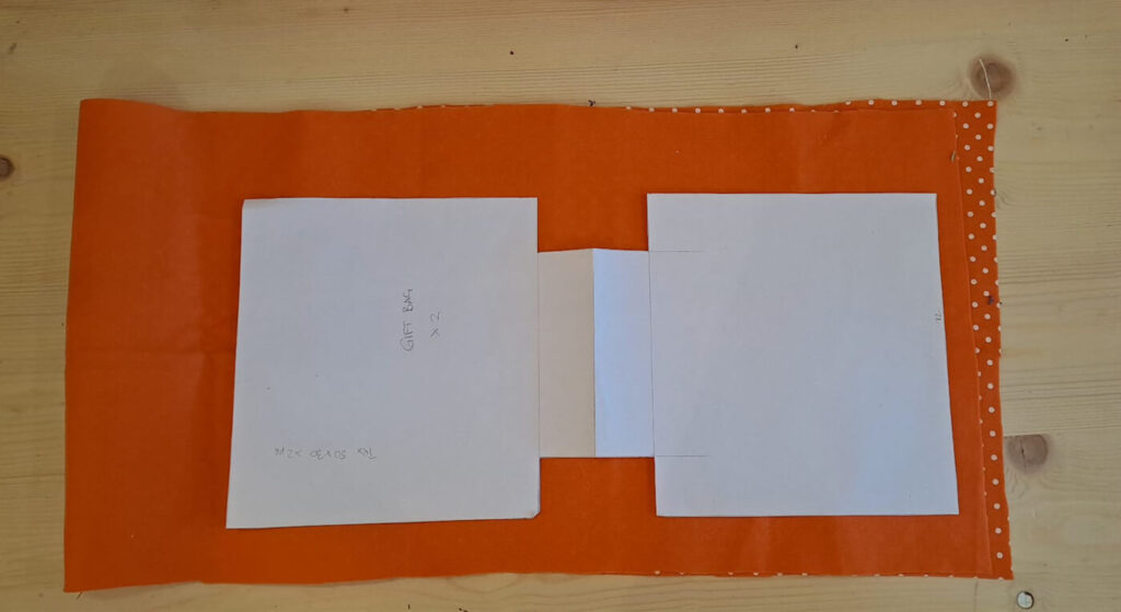 Foto che spiega come appoggiare il cartamodello della borsa sul tessuto in pannolenci arancione