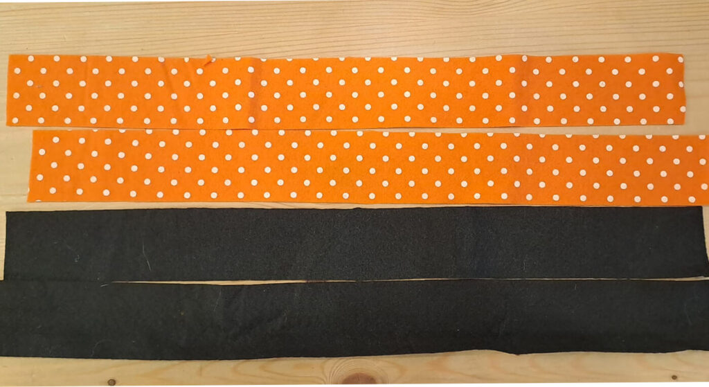 Due strisce arancioni e due nere, tagliate in misura per i manici della borsetta