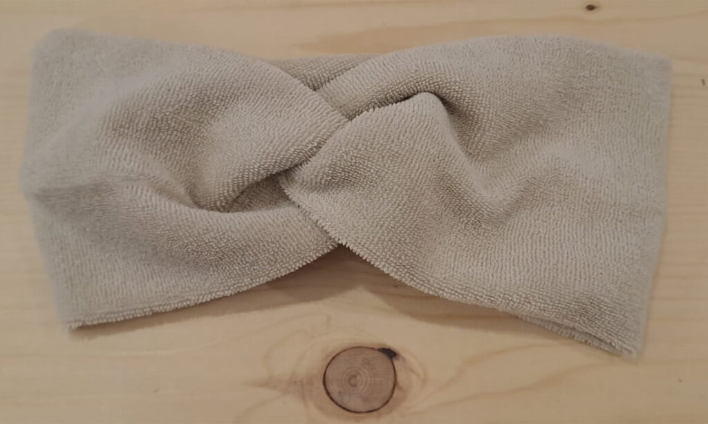 Fascetta in spugna di bambù in colorazione naturale, intrecciata sulla parte superiore, adatta per lo skincare